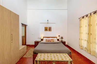 a bedroom with a bed and a bench in it at Sliceinn Somewhere Together In Biligeri in Madikeri