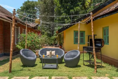 a backyard with a table and chairs and a grill at Sliceinn Somewhere Together In Biligeri in Madikeri