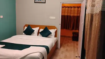 a bedroom with a bed with green and white pillows at Retro Radiance in Ooty