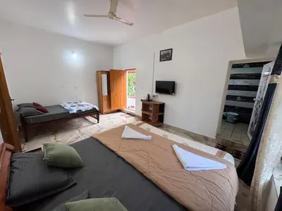 a bedroom with a large bed in a room at Sukhavana home stay suite in Madikeri