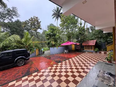 a car parked in a courtyard with a checkered floor at Sukhavana home stay suite in Madikeri