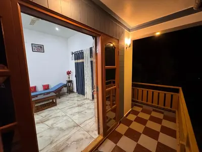 a room with a door and a checkerboard floor at Sukhavana home stay suite in Madikeri
