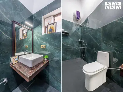 a bathroom with a sink and a toilet and a mirror at StayVista at Ambrosia access to water stream in Kotagiri