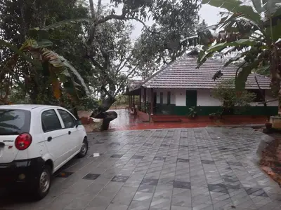 a white car parked in front of a house at Ophel Homestay, 7 Bed Heritage Home in Mananthavady
