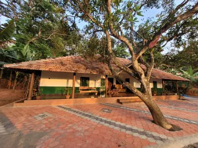 a small building with a tree in front of it at Ophel Homestay, 7 Bed Heritage Home in Mananthavady