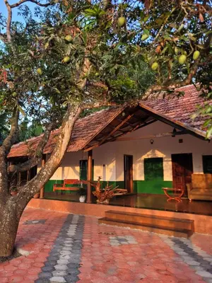 a house with a tree in front of it at Ophel Homestay, 7 Bed Heritage Home in Mananthavady