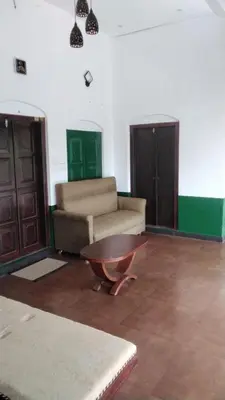 a living room with a couch and a coffee table at Ophel Homestay, 7 Bed Heritage Home in Mananthavady