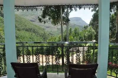 a balcony with chairs and a view of mountains at Sahari Villa, Vattavada in Vattavada