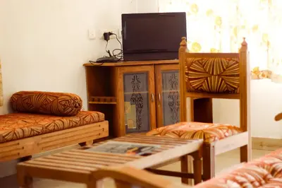 a living room with a tv and two chairs at Sahari Villa, Vattavada in Vattavada