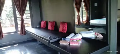 a room with a couch with pillows on it at Ranches & Kennels 2BR Coorg in Kushālnagar