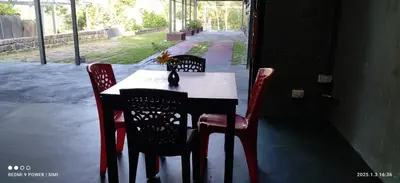a table with four chairs and a table and a table and chairsearcher at Ranches & Kennels 2BR Coorg in Kushālnagar