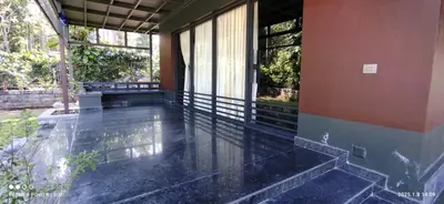an empty porch of a house with water on the floor at Hidden Haven 1BR Coorg in Kushālnagar