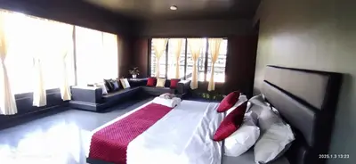 a bedroom with a large bed with red and white pillows at Coorg Countryside 1BR in Kushālnagar