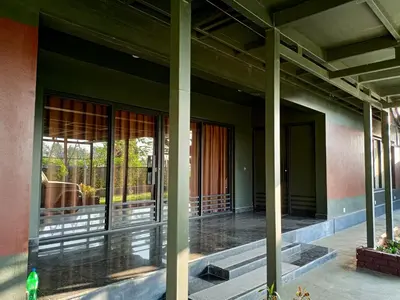 a building with glass doors with a horse outside at Coorg Countryside 1BR in Kushālnagar