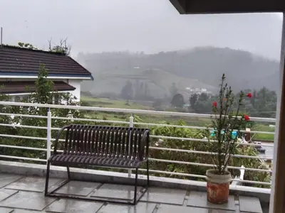 a bench sitting on a balcony with a view at Little heaven in Ooty