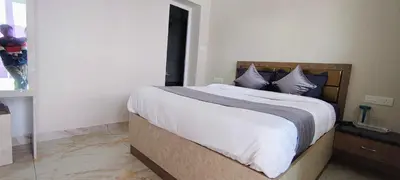 a bedroom with a bed with white sheets and blue pillows at Little heaven in Ooty