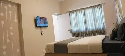 a bedroom with a bed with a window and a television at Little heaven in Ooty