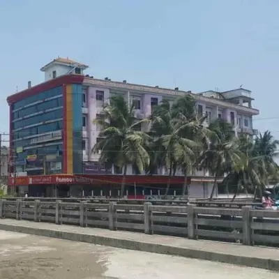 a large building with palm trees in front of it at K M S Residency in Tirūr