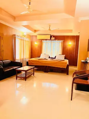 a bedroom with a bed and a living room at K M S Residency in Tirūr