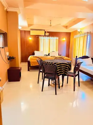 a room with a table and chairs and a bed at K M S Residency in Tirūr