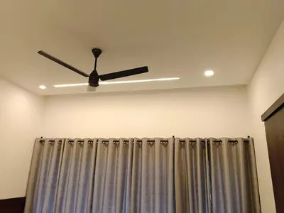 a ceiling fan in a room with a curtain at The Tree House in Vythiri