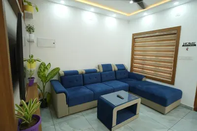 a living room with a blue couch and a table at Wayanadanhuts Home Stay in Sultan Bathery