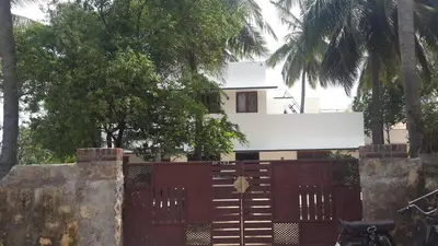 a house behind a fence with a gate at Anand Bagh in Pollāchi