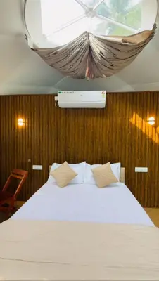 a bedroom with a white bed with a window at Rivergreen resort in Athirappally