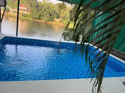 a swimming pool with a view of a river at Rivergreen resort in Athirappally