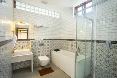 a bathroom with a tub and a toilet and a sink at Koviloor Resort in Vattavada