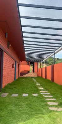a building with a roof with green grass in a courtyard at H2cottage in Wodapatti