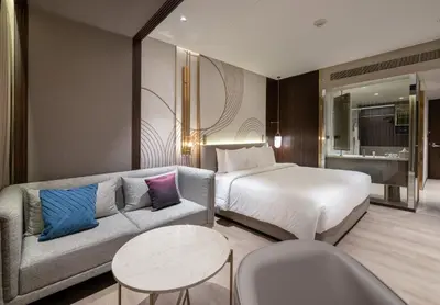 a hotel room with a bed and a couch at Merlis Hotel Coimbatore in Coimbatore