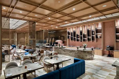 a restaurant with tables and chairs and a lobby at Merlis Hotel Coimbatore in Coimbatore