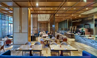 a dining room with tables and chairs and a restaurant at Merlis Hotel Coimbatore in Coimbatore