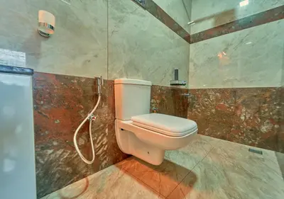 a bathroom with a toilet and a shower at Ooty Blossom Retreat by VOYE HOMES in Ooty
