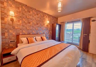 a bedroom with a large bed and a brick wall at Ooty Blossom Retreat by VOYE HOMES in Ooty
