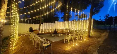 an outdoor wedding with lights and white chairs at GVK Holiday Inn in Mysore