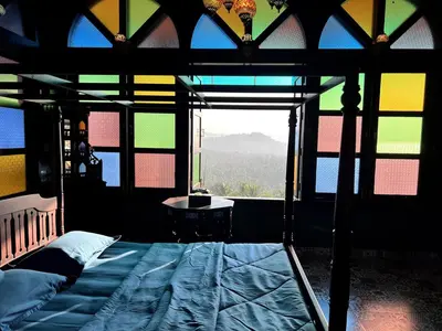a bedroom with a bed and a window with a view at Room Marakkech Mazha at Samava Farms Calicut in Kozhikode