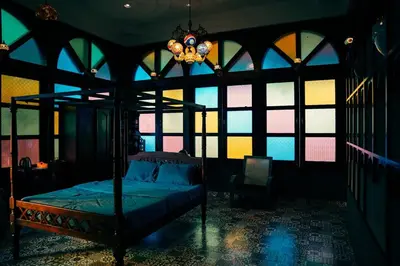 a bedroom with a bed with a chandelier and windows at Room Marakkech Mazha at Samava Farms Calicut in Kozhikode