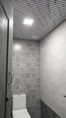 a bathroom with a toilet and a tile wall at Eagles Nest in Dimbam