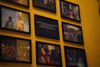 a wall of pictures on a yellow wall at Room Suvira at Samava Farms Calicut in Kozhikode