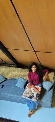a young girl sitting on a bed in a tent at Cherry Blossoms Chalet in Kozhikode