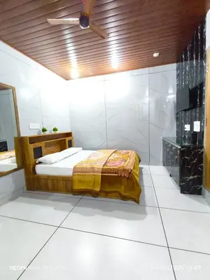 a bedroom with a bed and a ceiling at Diyara's Inn in Madikeri