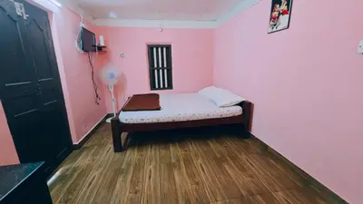 a small bedroom with a bed in a pink room at Coffeeisland vintage stay in Meenangadi