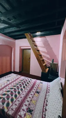 a bedroom with a bed and a wooden staircase at Coffeeisland vintage stay in Meenangadi