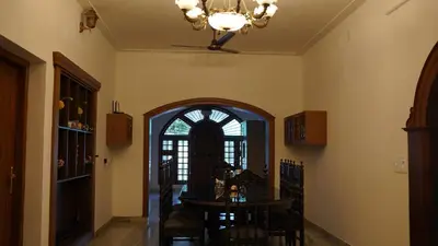 a dining room with a table and a chandelier at Hotel Vintage Palace in Tattamangalam