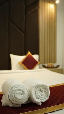 a pile of towels sitting on top of a bed at Hotel Vintage Palace in Tattamangalam