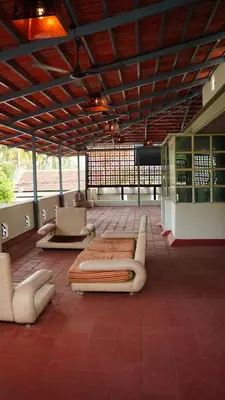 a room with benches and tables in a building at Hotel Vintage Palace in Tattamangalam
