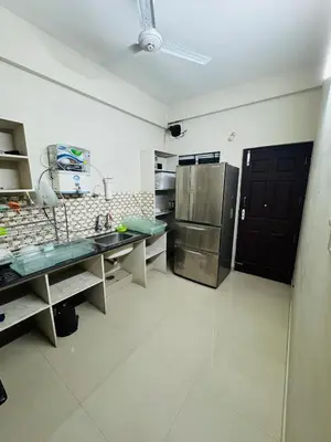 a kitchen with a sink and a refrigerator at Harmony Nests in Thattakād