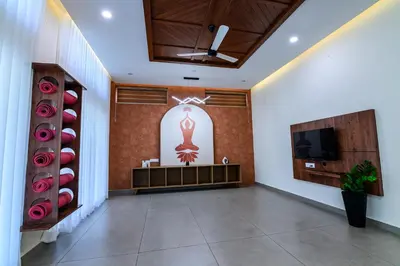 a lobby with a waiting area with a tv and a wall at Dr Indulekhas Ayurvedic Wellness & Rejuvenation in Tellicherry